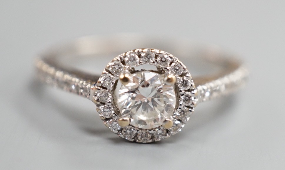 A modern 18ct white gold and single stone diamond ring with diamond chip circular setting and diamond chip set shoulders, from The Diamond Store, London